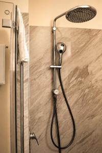 a shower with a shower head in a bathroom at Les Jardins Blankenese in Hamburg
