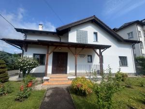 a white house with a porch and a door at Pensiunea Funivia in Săcele
