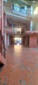 an empty building with two balconies and a brick floor at Hostal Cadena in Tupiza