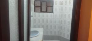 a bathroom with a toilet and a window at Hostal Cadena in Tupiza
