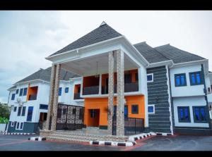 a large house with a porch in a parking lot at Blu Atlantic Apartment in Oshogbo