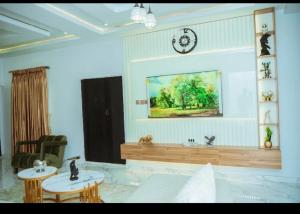 a living room with two tables and a clock on the wall at Blu Atlantic Apartment in Oshogbo