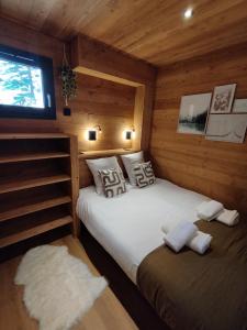 a bedroom with two beds in a wooden cabin at Les 2 Chalets Alpins & Bains Nordiques in Saint-Michel-de-Chaillol