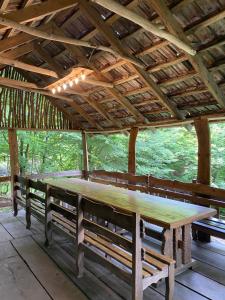 a large wooden table in a pavilion with benches at Dili Dzor in Dilijan