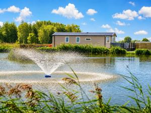 a fountain in the middle of a body of water at Parkside Fishery in Skegness
