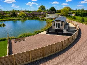 a retaining wall next to a river with a house at Parkside Fishery in Skegness