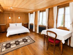 two beds in a room with wooden floors and windows at Klösterli Malters in Malters