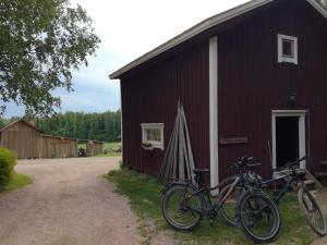two bikes parked outside of a red barn at Luomajärven Hevoskievari in Karhoinen +72 photos