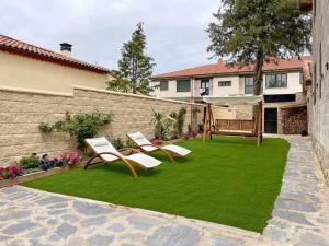 a yard with two lawn chairs and an umbrella at Casa Rural el Cedro in Abejar