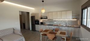 a kitchen with a table and chairs and a couch at Casa Ligoustra in Kalithies