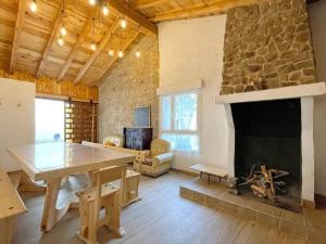 a living room with a stone fireplace and a table at Casa Rural el Cedro in Abejar