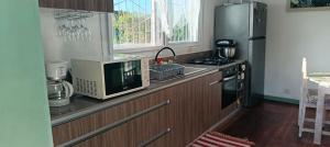a kitchen with a counter with a microwave and a refrigerator at Villa Jasmin, NOSY BE in Ambaro