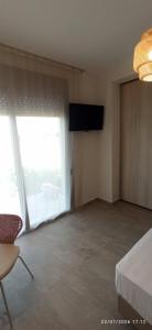a room with a television and a large window at Casa Ligoustra in Kalithies
