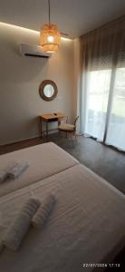 a bedroom with a large white bed with a table at Casa Ligoustra in Kalithies