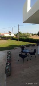 a patio with two chairs and a table and flowers at Casa Ligoustra in Kalithies