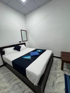 a bedroom with a large bed with blue pillows at Diving Club Beach Resort in Trincomalee