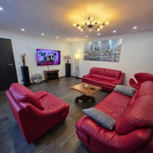 a living room with red furniture and a flat screen tv at Martin Ferienhaus in Burg bei Magdeburg