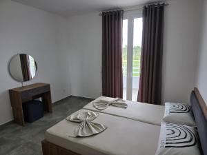a bedroom with two beds and a mirror and a window at Villa Lumi Mat in (( Mal i Kakariqit )) +27 photos