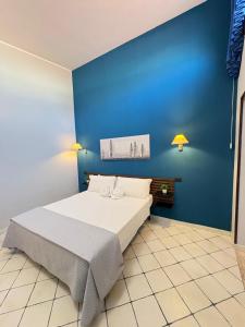 a bedroom with a large bed with a blue wall at Sun Tower beach apartments in Mazara del Vallo