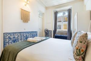 a bedroom with a white bed and a window at Gonzalo's Guest Apartments - Downtown Historic Flats in Lisbon