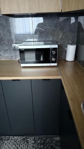 a microwave sitting on top of a wooden counter at Квартира в центре города in Komrat +6 photos