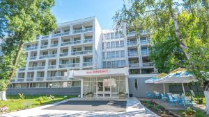 an apartment building with a patio in front of it at Hotel Semiramis in Saturn