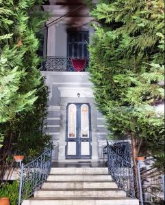 a blue door on a white house with trees at Archontiko Olympias Boutique Hotel in Mytilene