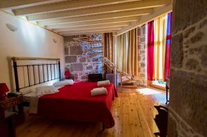 a bedroom with a red bed in a brick wall at Archontiko Olympias Boutique Hotel in Mytilene