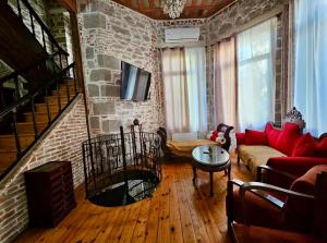 a living room with a red couch and a brick wall at Archontiko Olympias Boutique Hotel in Mytilene