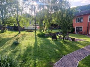 a yard with trees and a brick path at Haus Rothenberg - Wohnung Anne in Nohfelden