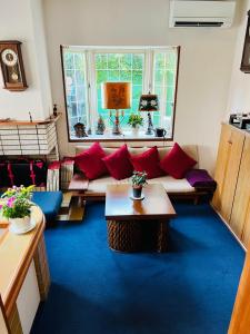 a living room with a couch and red pillows at Pension Green Grass in Kamakura
