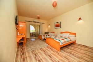 a bedroom with two beds and a desk and a television at Sun Lake Hotel in Tunis