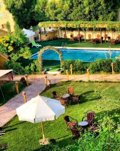 a garden with an umbrella and chairs and a pool at Sun Lake Hotel in Tunis