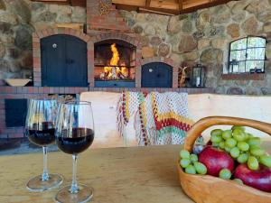 two glasses of wine sitting on a table with a basket of fruit at Gościniec Sarnówka 