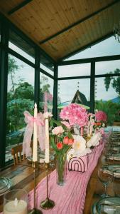 a table with pink flowers and candles on it at Eucalyptus Cottages in Chakvi +14 photos