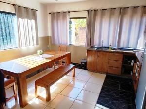 a living room with a wooden table and a kitchen at Apartemento Grande Hohenau Centro in Hohenau