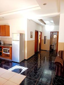 a kitchen with a refrigerator in the middle of a room at Apartemento Grande Hohenau Centro in Hohenau +8 photos
