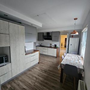 a kitchen with a table and a dining room at Domki Oliwia in Łeba