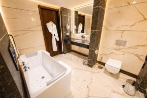 a bathroom with a tub and a sink and a toilet at Hotel Space Crest in Faisalabad +8 photos