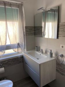 a bathroom with a sink and a mirror and a toilet at PM 29 Guest House in Alghero +38 photos