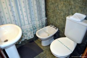 a bathroom with a white toilet and a sink at Cabañas Las Maras in Villa La Angostura