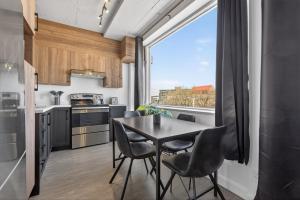 a kitchen with a table and chairs and a large window at Lofts Orizon in Rimouski