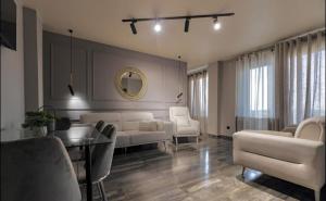 a living room with white furniture and a mirror at Sunmore in Kobuleti