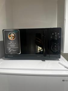 a black microwave oven sitting on top of a counter at Apartament NOVA in Nowa Ruda