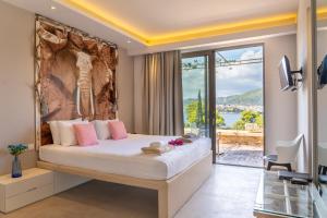 a bedroom with a large bed and a large window at Core Luxury Suites in Skiathos