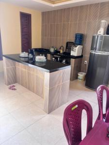 a kitchen with a black counter top in a room at Casa Annas - Conforto e Tranquilidade in Icaraí