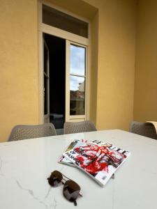 a table with a magazine and a pair of sunglasses on it at Deluxe Center Suites in Chania