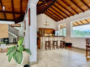 an open kitchen and dining room with wooden ceilings at Nature Breeze Boutique Villa in Kandy