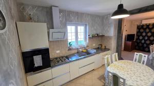 a kitchen with a sink and a stove and a table at New Big Butterfly Rooms - Free parking in Koper