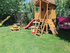 a playground with a play house and a slide at DVOR seosko turisticko domacinstvo in Donja Toponica